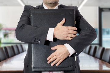 Uomo in ufficio con valigetta stretta