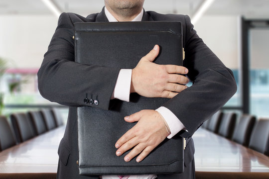 Uomo in ufficio con valigetta stretta