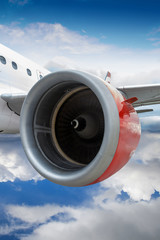 Airplane With Red Engine Flying Through Clouds