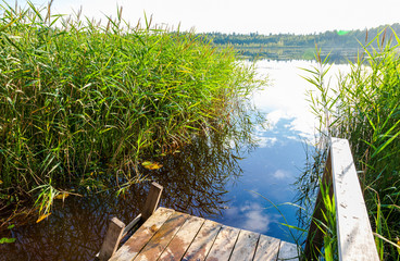 Summer landscape with lake and wooden bridge