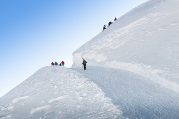 Fototapeta na wymiar Group of skiers walks up the hill