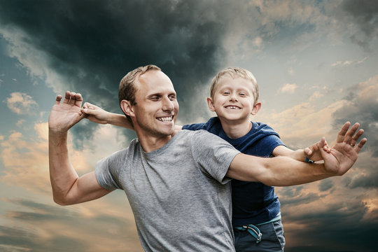 Happy smiling son with father portrait on the cold tones sky