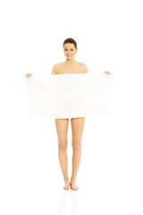 Beautiful woman holding a white towel and covering herself