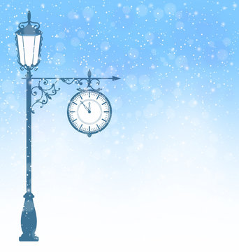 Vintage winter lamppost with clock in snowfall on blue backgroun