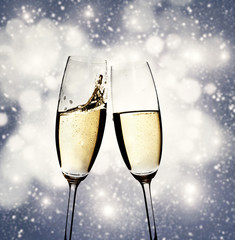 Toasting with champagne glasses on sparkling holiday background