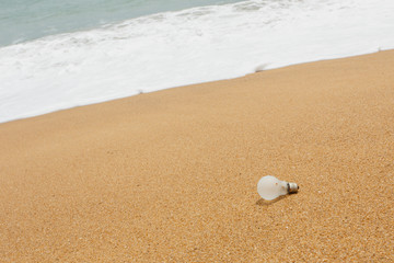 Old light bulb on the beach