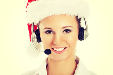 Young business woman in santa hat, microphone and headphones.