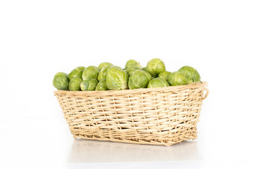 Basket full of brussel sprouts isolated on white