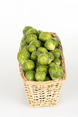 Basket full of brussel sprouts isolated on white