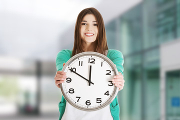 Happy woman holding office clock