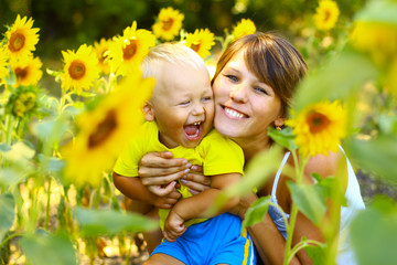 Mom with a little boy in sunflowers - 73503634