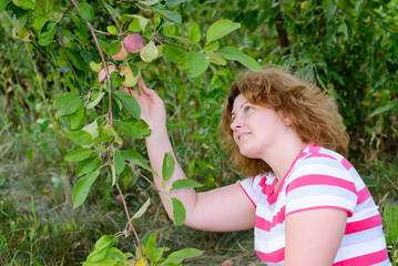 middle-aged woman in a garden about Apple trees