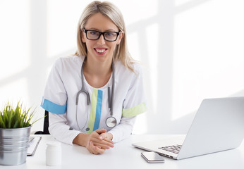 Female doctor sitting at the desk in the office