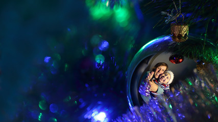 Woman with child reflected in the Christmas ball