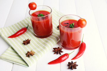 Tomato juice in glasses and fresh vegetables