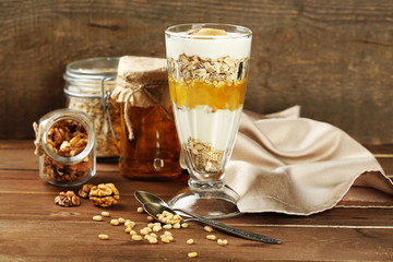 Tasty dessert with oat flakes and honey, on table