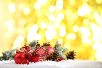 Christmas balls on snow on bright background