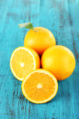 Ripe tangerines and oranges with leaves on wooden background