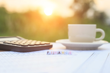 Finance written in letter beads and a coffee cup on table
