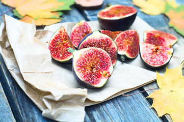 Figs and automn yellow leaves on the wooden rustic surface