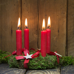 Adventskranz mit vier roten brennenden Kerzen