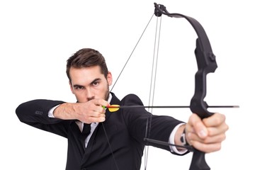 Smart businessman practicing archery looking at camera
