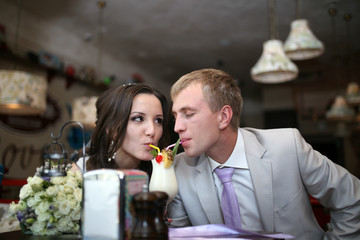 Жених с невестой пьют вместе коктейль