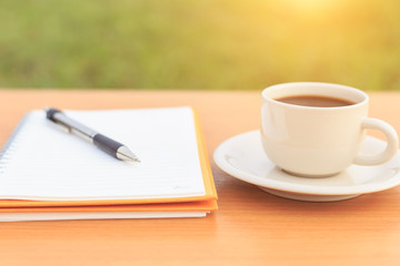 Close up coffee cup and notebook on the table
