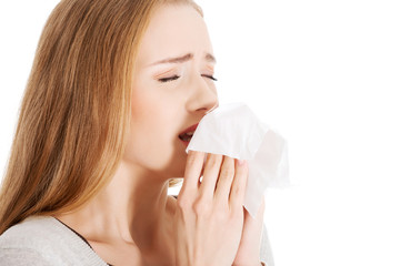 Close up woman holding tissue sneezing