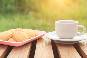 Close up coffee cup and cookie on the table in the morning
