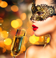 Sexy model woman with glass of champagne wearing mask