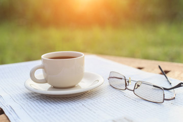 Close up Coffee cup and newspaper on the table in the morning