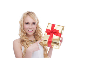 Hübsche blonde Frau zeigt auf Weihnachtsgeschenk
