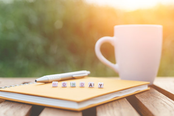 Monday written in letter beads and a coffee cup on table