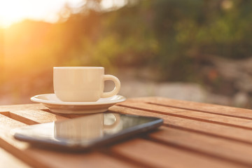 A cup of coffee and smartphone on the table