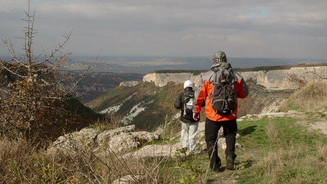 Hiking people on edge of plateau in Crimean mountains