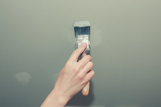 Hand of young woman painting a wall