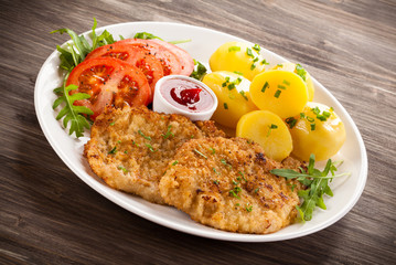 Fried pork chop, boiled potatoes and vegetable salad