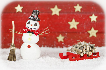 Snowman with sleigh on red background