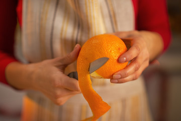 Closeup on young housewife removing orange peel