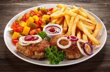 Fried chops, French fries and vegetable salad