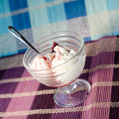 Glass bowl of icecream with raspberry topping