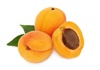 Two whole and a half apricot with leaves (isolated)