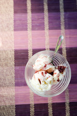 Glass bowl of icecream with raspberry topping
