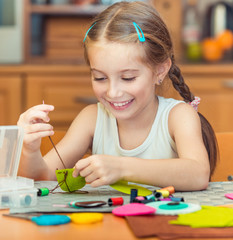 little girl is engaged in needlework