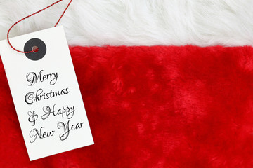 Christmas wishes on white tag on santas red fur