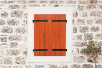 retro window with wooden shutters and stone walls