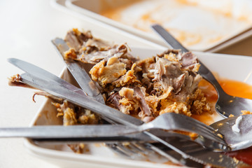 Plate with remnants of fried chicken in the restaurant