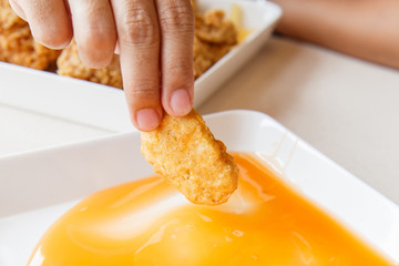 Hand holding Fried  chicken nuggets and eating in the restaurant