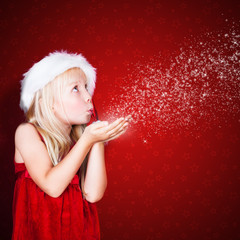 kleines Mädchen pustet Schneeflocken